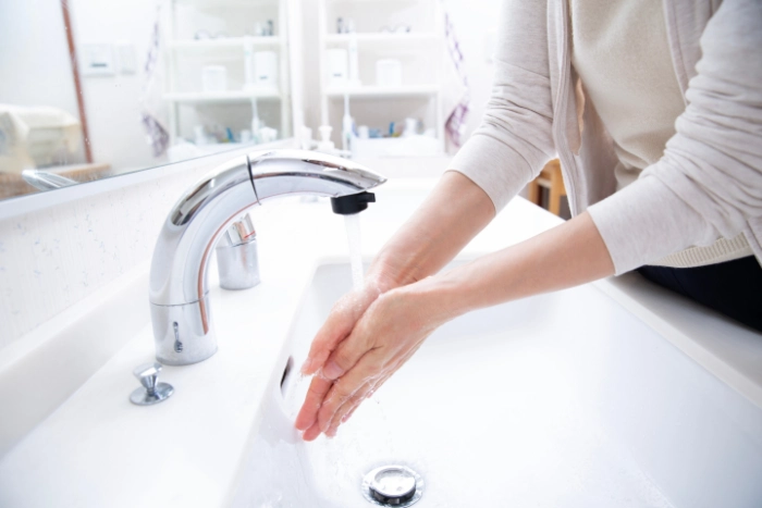 洗面所で手を洗う人